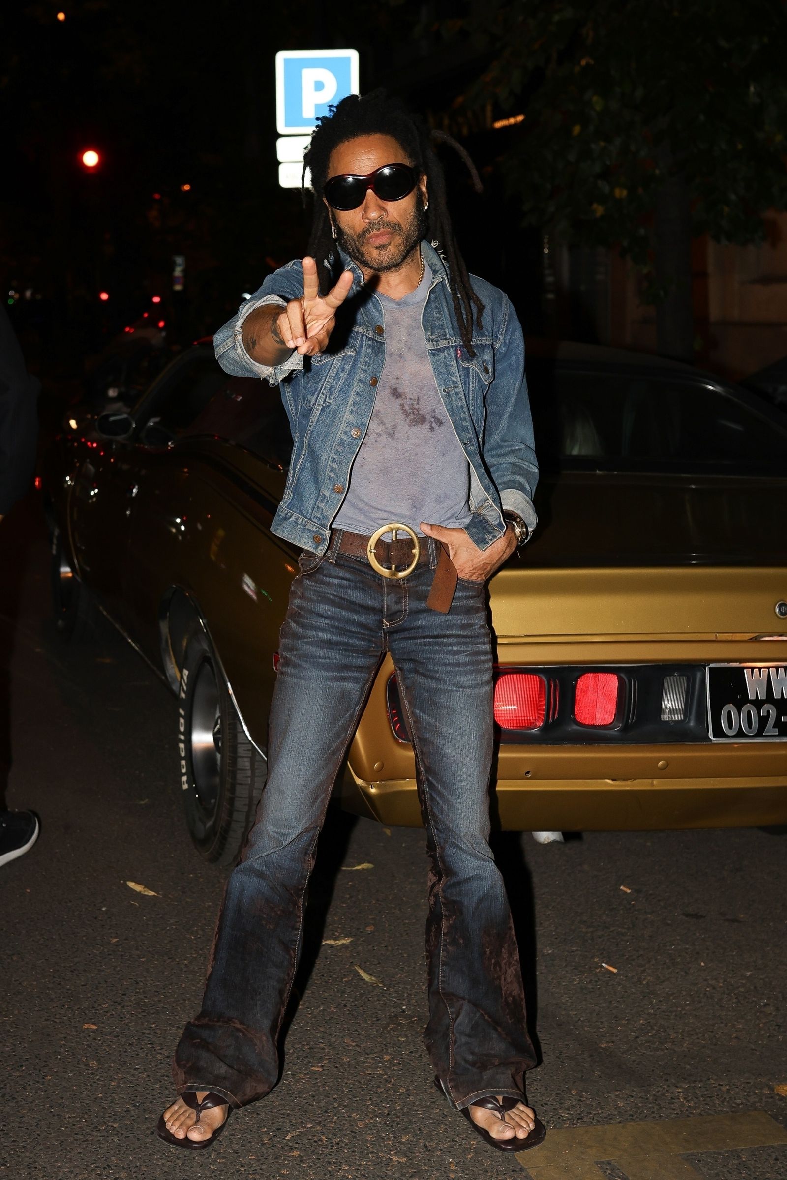 Paris FRANCE  EXCLUSIVE  Lenny Kravitz strikes a pose in front of his stunning goldyellow classic car in Paris casually...