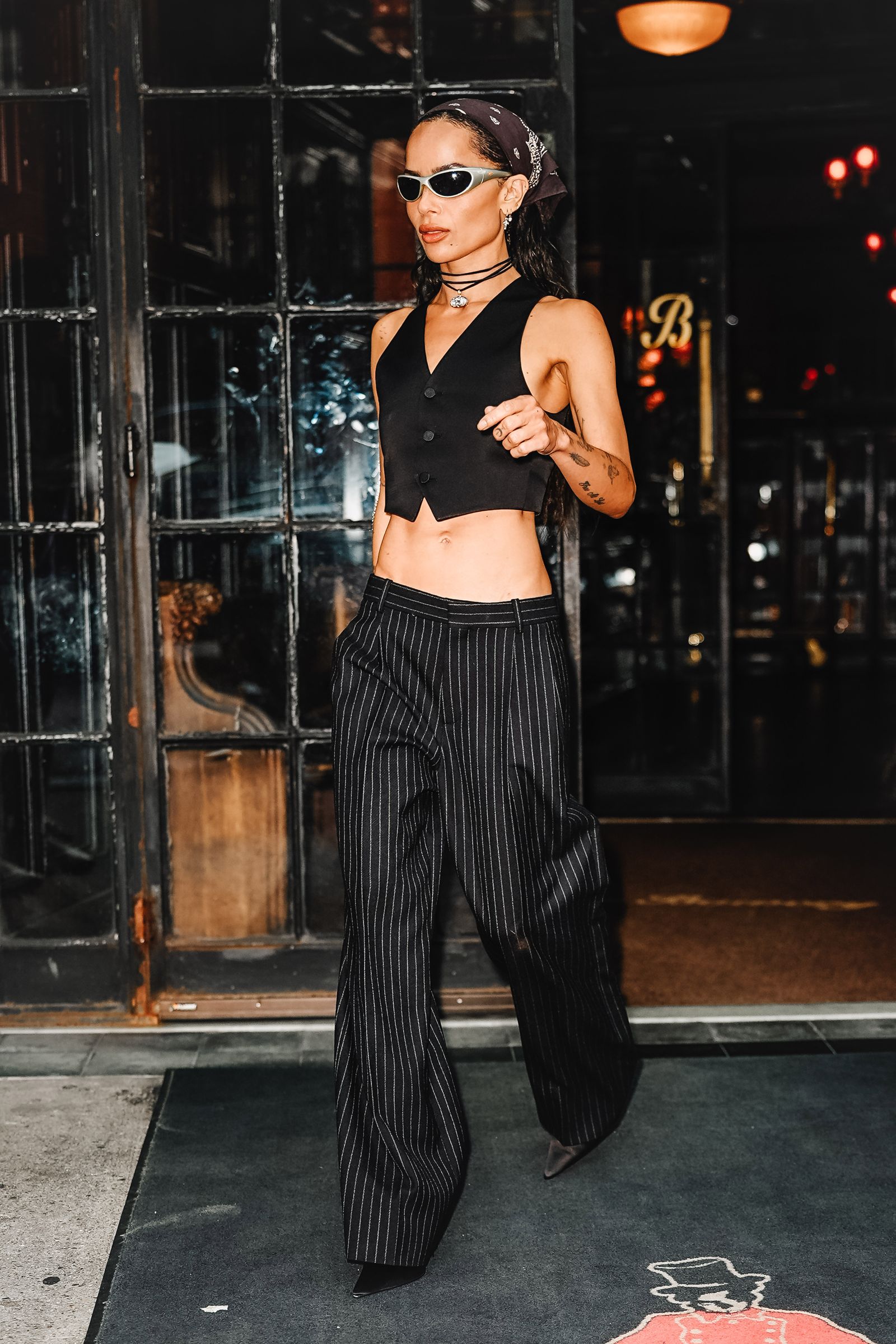 Image may contain Zoë Kravitz Clothing Pants Accessories Glasses Lamp Jewelry Necklace Adult Person and Footwear