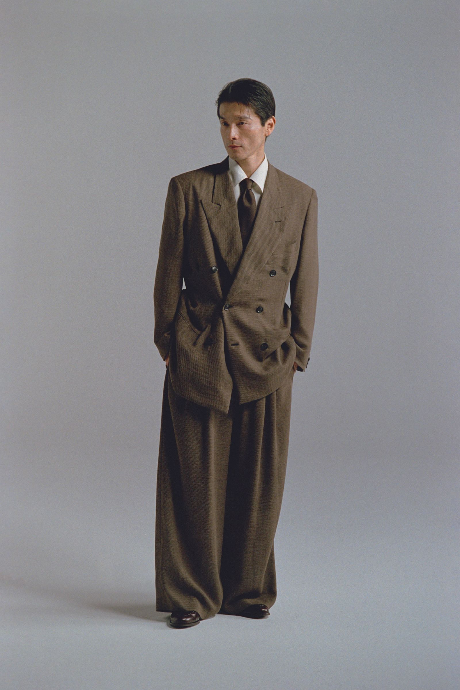 Image may contain Clothing Formal Wear Suit Coat Accessories Tie Adult Person Tuxedo Blazer Jacket and Overcoat