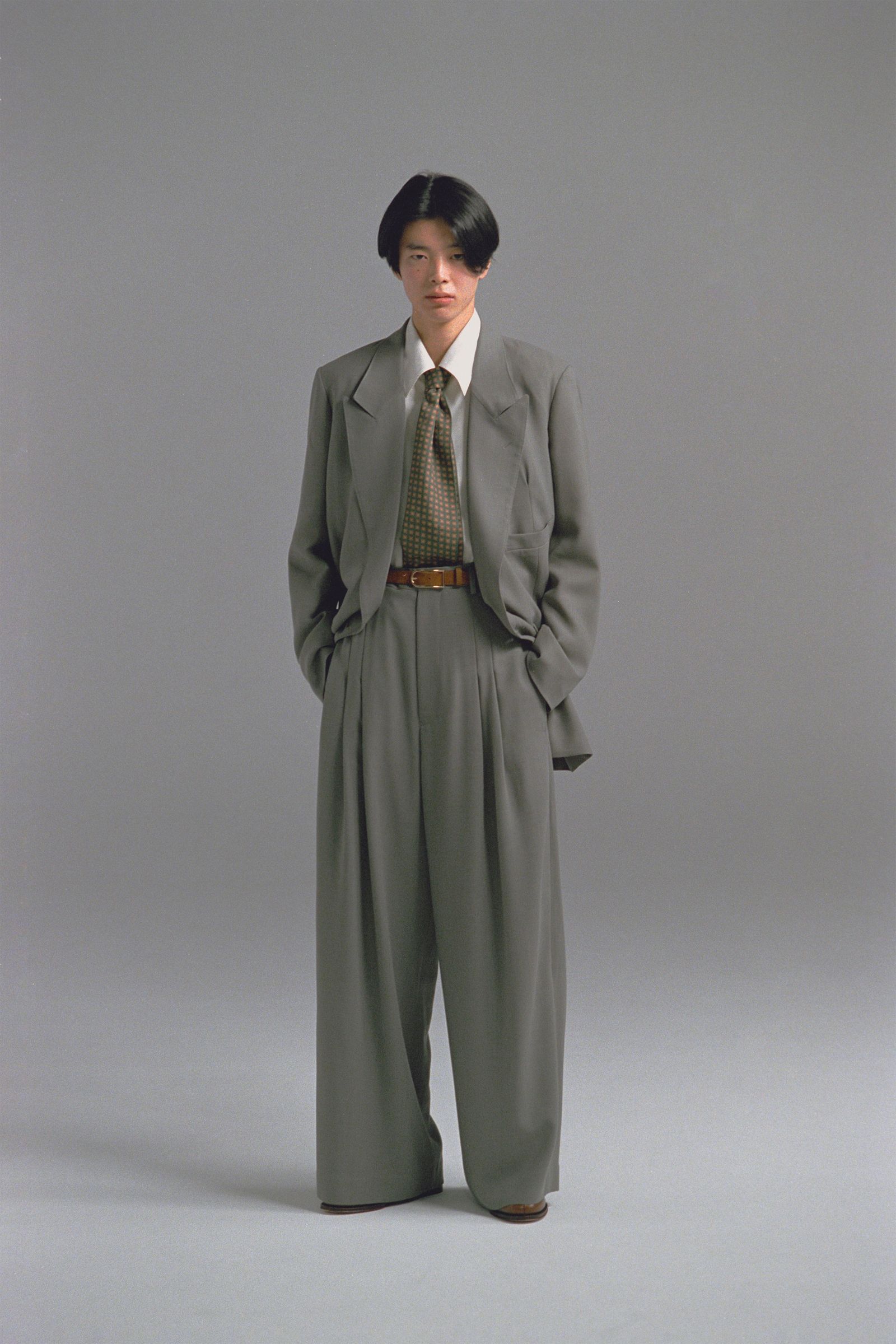 Image may contain Yeon Woojin Clothing Formal Wear Suit Coat Blazer Jacket Adult Person Accessories Tie and Belt