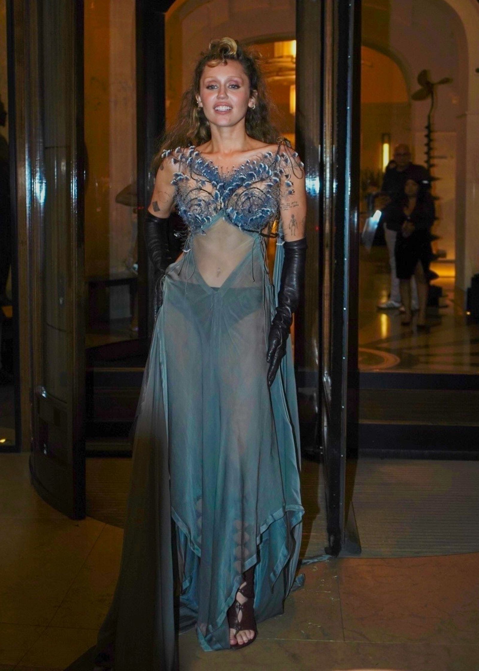 Miley Cyrus stuns in sheer gown while greeting fans outside her Paris hotel