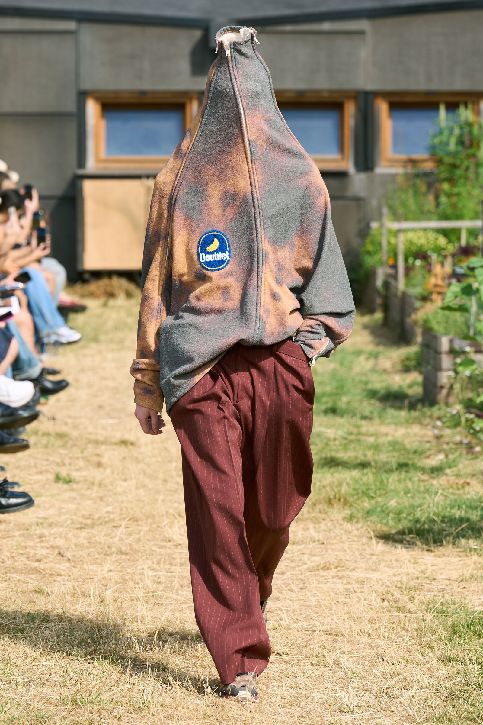 Image may contain Clothing Pants Person Walking Footwear Shoe Grass Plant People Electronics and Mobile Phone