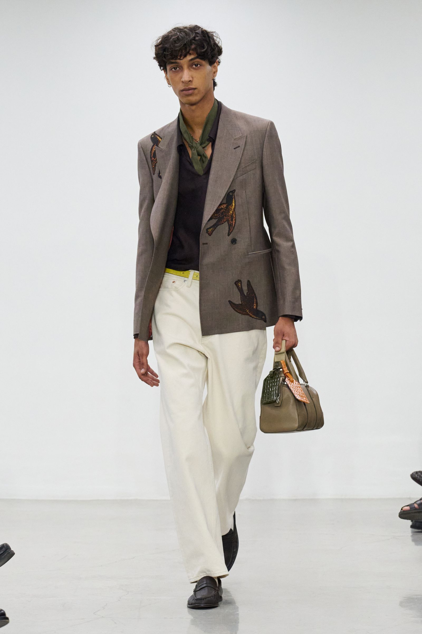 Image may contain Blazer Clothing Coat Jacket Formal Wear Suit Adult Person Pants Accessories Bag and Handbag