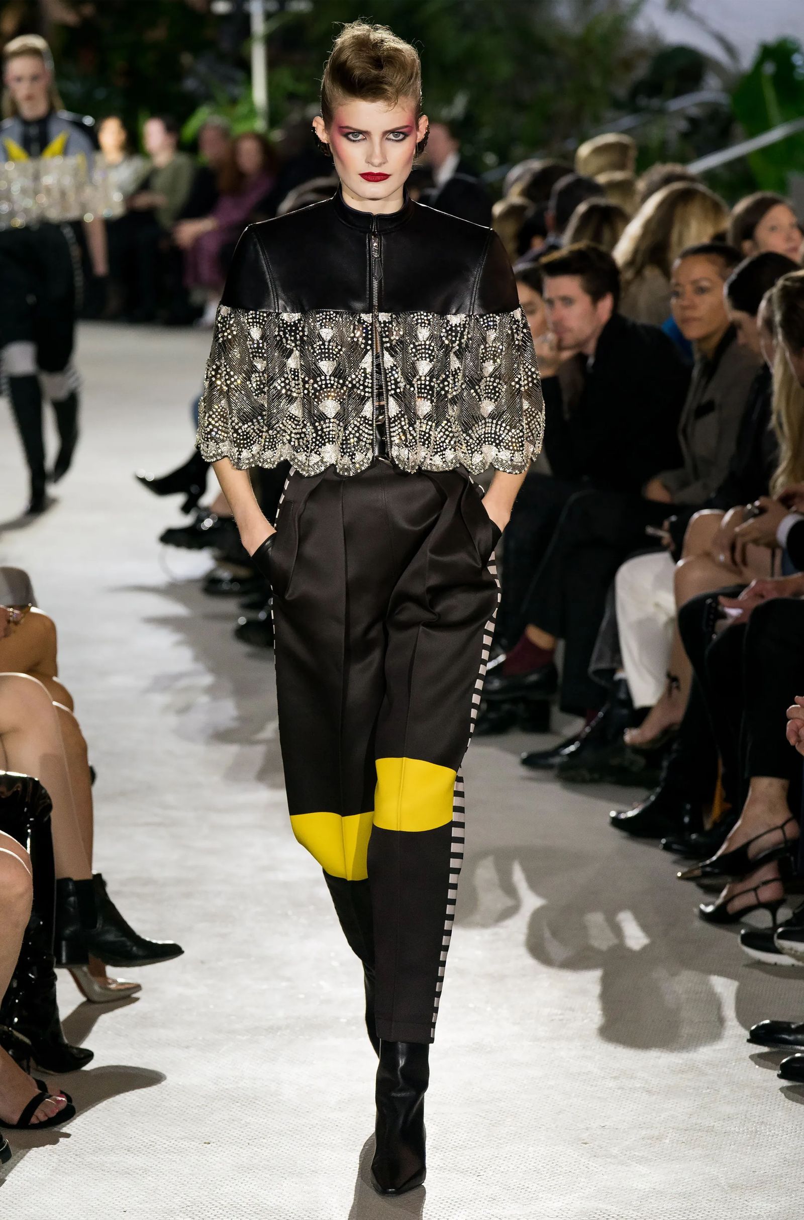 Image may contain Adult Person Clothing Sleeve Fashion Footwear High Heel Shoe Pants and Runway